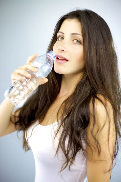 Чудова жінка готова пити воду в студії з пляшки — стокове фото