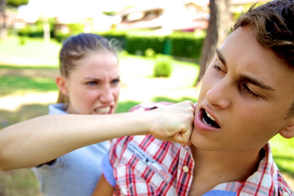 Angry girlfriend punching boyfriend — Stock Photo, Image