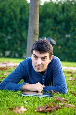 yakışıklı gülümseyen adam okuma tablet-sonbahar Park