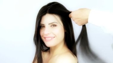 Kuaför fırçalama ve uzun ipeksi siyah saçları ütü yaparken kadın