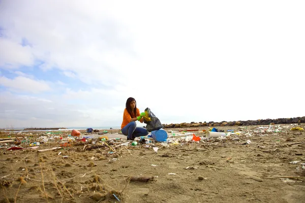 Joven activista limpiando playa sucia — Foto de Stock