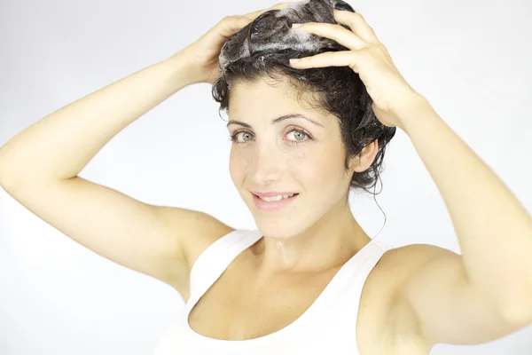 Щаслива жінка миє волосся шампунем — стокове фото