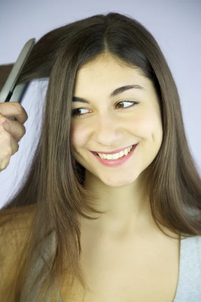 Frau sehr glücklich darüber, sich Haare machen und bügeln zu lassen — Stockfoto