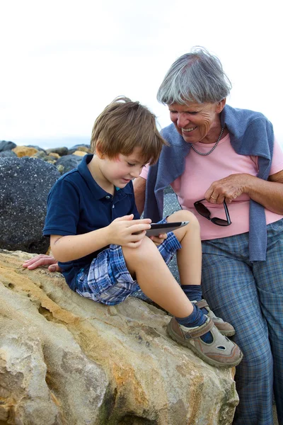 Child having fun with grandmother with tablet outdoors — Stock Photo, Image