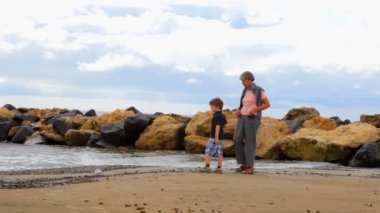 Büyükanne ile plajda oynayan çocuk