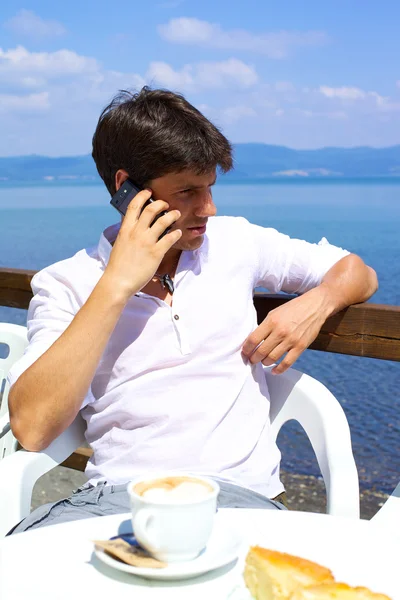 Homme d'affaires sérieux parlant au téléphone pendant le petit déjeuner en vacances en Italie — Photo