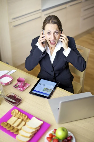 Mujer de negocios gritando tener conversación con dos teléfonos volviendo loco —  Fotos de Stock