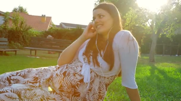 Έγκυος γυναίκα χαλαρώνοντας στον κήπο — Αρχείο Βίντεο