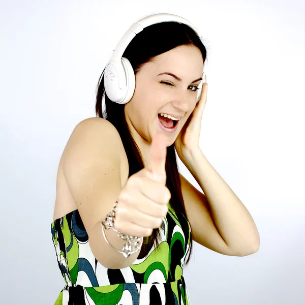 Feliz linda chica escuchando música pulgar hacia arriba — Foto de Stock