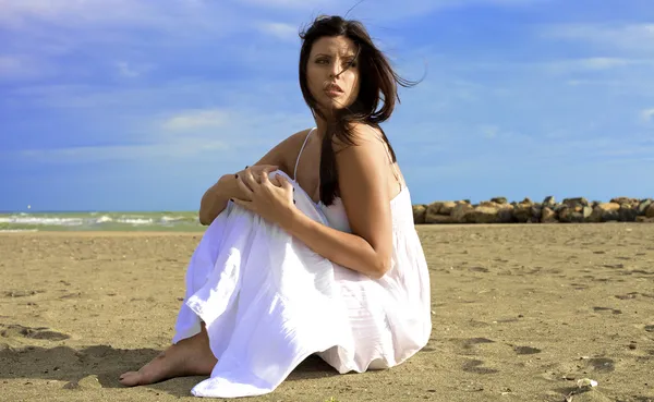 Vrouw poseren met storm komt op strand — Stockfoto