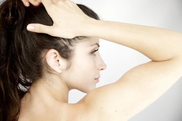 Imagen de la pureza de la mujer sosteniendo el cabello en cola de caballo —  Fotos de Stock