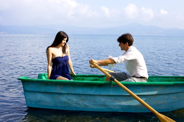 Woman in love looking boyfriend rowing boat — Stock Photo, Image