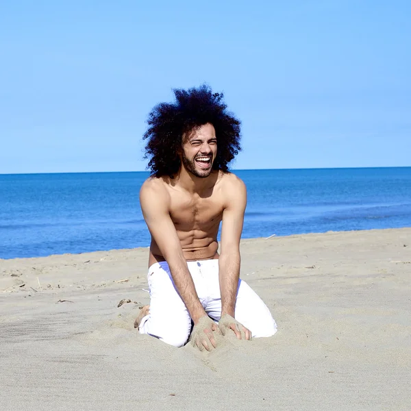 Modelo masculino ajuste bonito legal sorrindo se divertindo com areia em férias — Fotografia de Stock