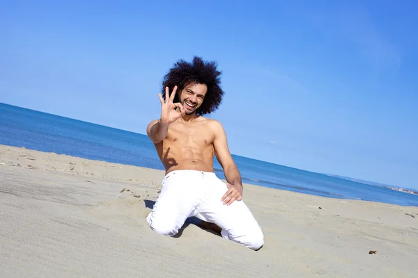Fajny model mężczyzna bez koszuli na plaży ok znak — Zdjęcie stockowe