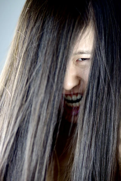 Shouting asian female monster with long hair on face — Stock Photo, Image