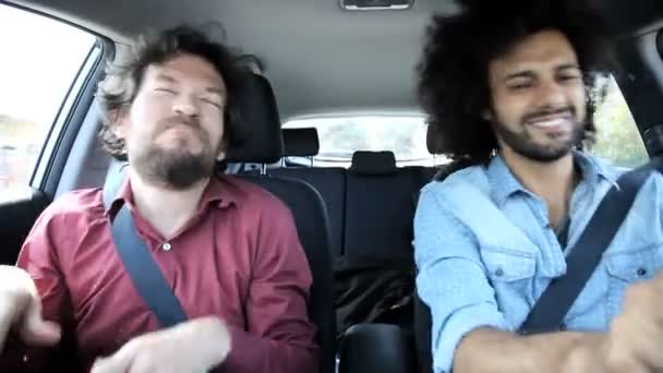 Два друга поют и танцуют в машине — стоковое видео