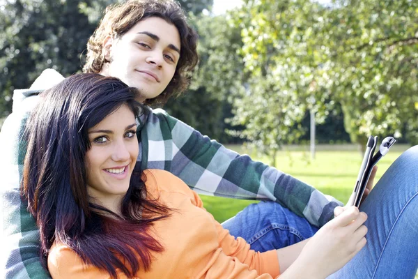 Couple tablette de lecture dans le parc — Photo