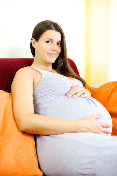 Happy beautiful pregnant woman holding baby — Stock Photo, Image