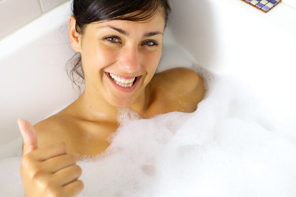 Happy girl taking relaxing bath thumb up