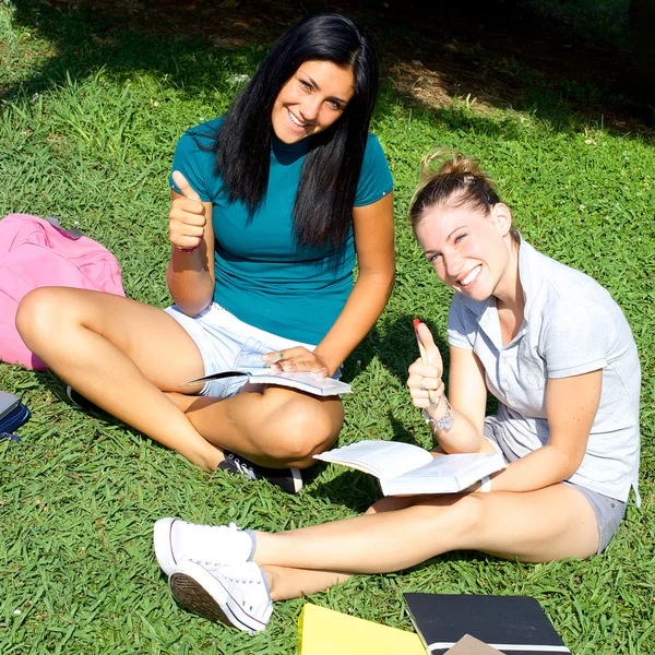 Två kvinnliga studenter glad tummen upp — Stockfoto