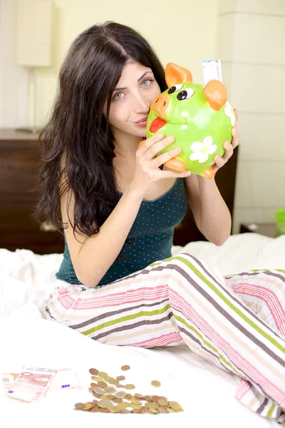 Happy woman hugging piggy bank full of money — Stock Photo, Image