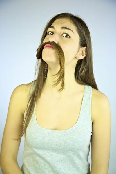Молодая женщина модель весело играет с волосами, как усы — стоковое фото