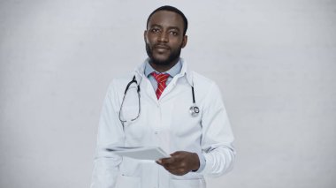 Sakallı Afrikalı Amerikalı doktor gri klasörü tutuyor.