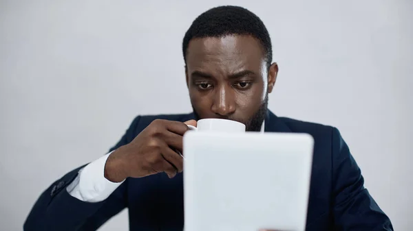 Hombre Negocios Afroamericano Utilizando Tableta Digital Mientras Bebe Café Aislado —  Fotos de Stock