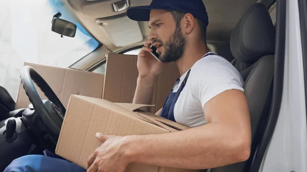 Zijaanzicht Van Boze Koerier Praten Smartphone Het Houden Van Kartonnen — Stockfoto