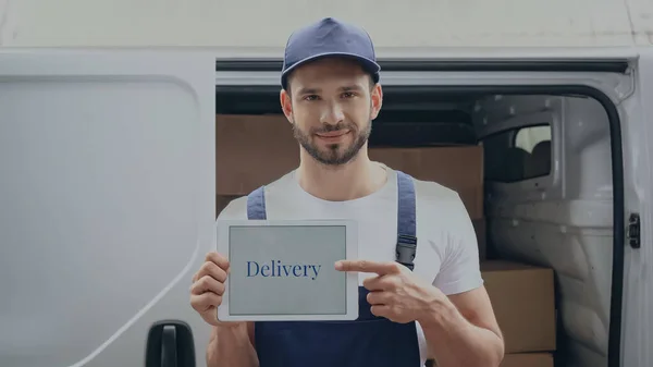 Lachende Bezorger Wijzend Met Digitale Tablet Met Belettering Buurt Van — Stockfoto