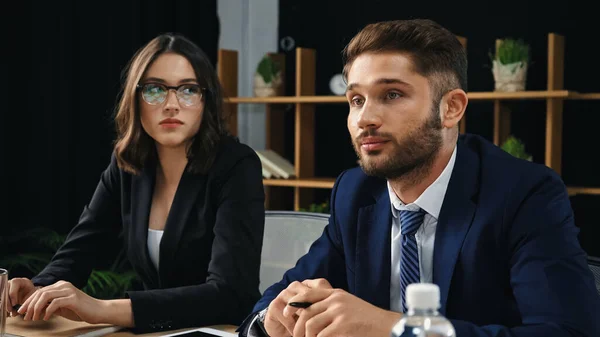 Sério Morena Empresária Óculos Olhando Para Jovem Colega Escritório — Fotografia de Stock