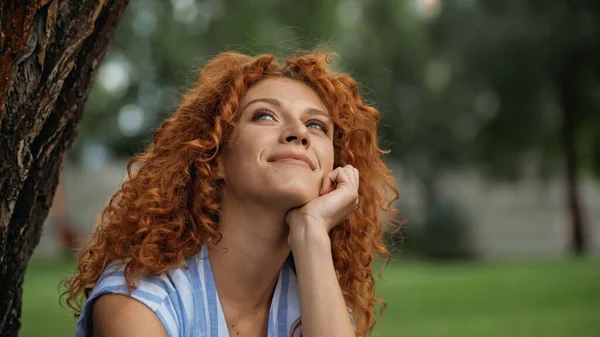 Мрійлива Жінка Кучерявим Волоссям Дивиться Вгору Посміхається Парку — стокове фото