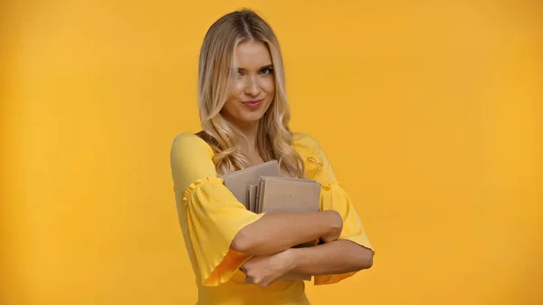 Mulher Loira Sorridente Com Livros Olhando Para Câmera Isolada Amarelo — Fotografia de Stock