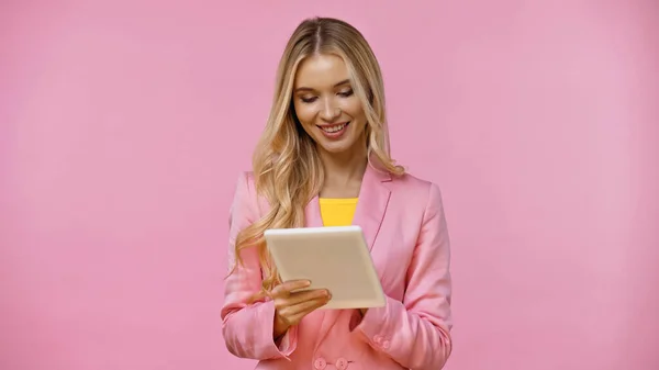 Uśmiechnięta Blondynka Korzystająca Cyfrowej Tabletki Odizolowanej Różowo — Zdjęcie stockowe