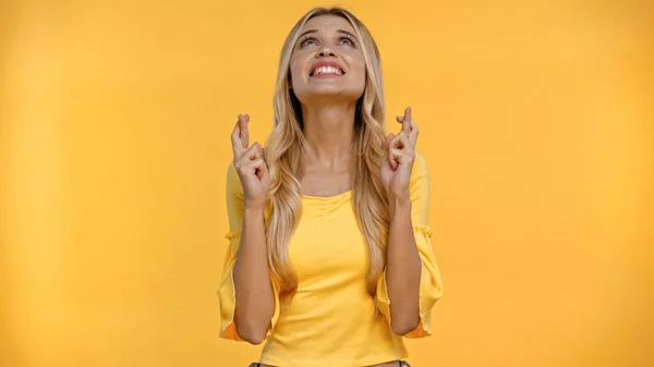 Mujer Rubia Mirando Hacia Arriba Cruzando Dedos Aislados Amarillo — Foto de Stock