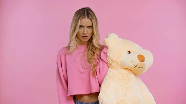 Ontevreden Blonde Vrouw Houden Zacht Speelgoed Geïsoleerd Roze — Stockfoto
