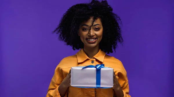 Feliz Mulher Afro Americana Com Aparelho Segurando Presente Envolto Isolado — Fotografia de Stock