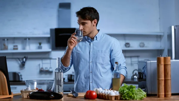 Joven Sosteniendo Vidrio Oliendo Vino Blanco Cerca Mesa Con Ingredientes — Foto de Stock