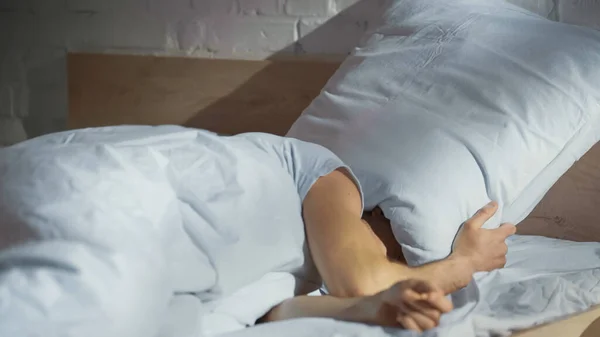 Homem Cobrindo Cabeça Com Travesseiro Enquanto Sofre Insônia — Fotografia de Stock