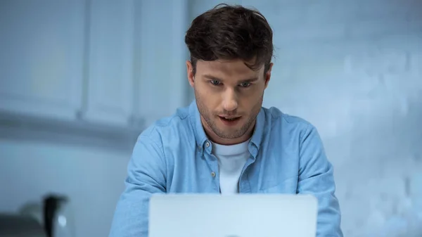 파란색 셔츠를 부엌에서 노트북으로 일하는 프리랜서들 집중되어 — 스톡 사진