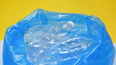 plastic bottles in garbage bag isolated on yellow  clipart