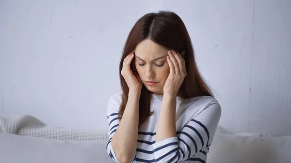 Migreni Olan Yorgun Bir Kadın Evde Otururken Kafasına Dokunuyor — Stok fotoğraf