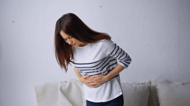 upset woman touching belly while suffering from stomach pain clipart