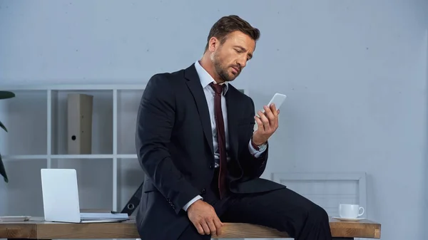 Homem Negócios Com Smartphone Sentado Mesa Perto Laptop Xícara Café — Fotografia de Stock