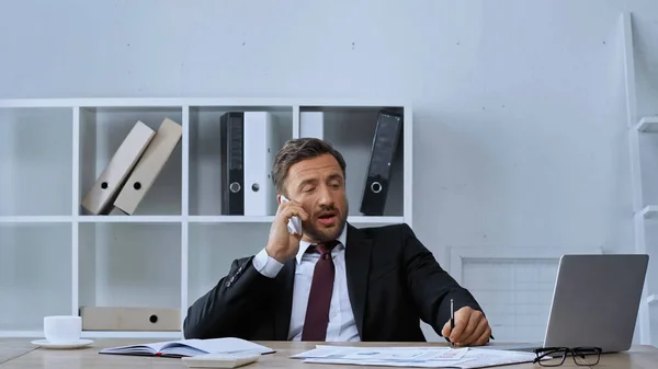 Homem Terno Falando Telefone Celular Perto Laptop Documentos Mesa — Fotografia de Stock