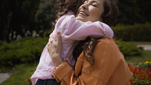 Daughter Hugging Happy Mother Closed Eyes Park — Stock Photo, Image