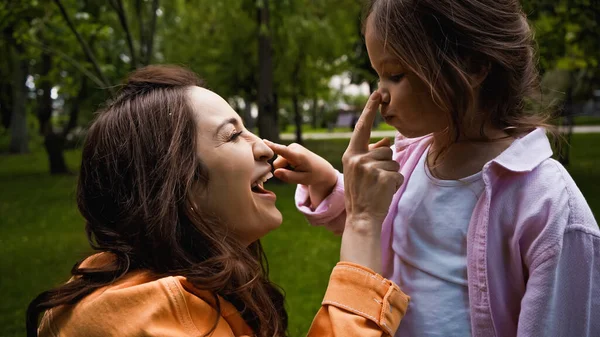 Side View Amazed Mother Touching Nose Cute Daughter Green Park — Fotografia de Stock