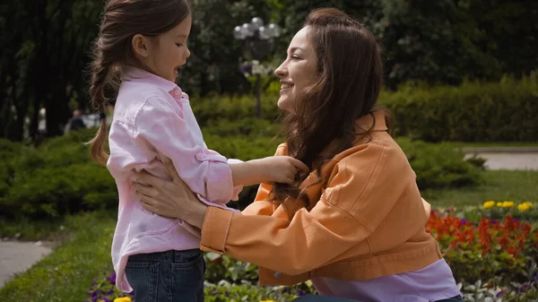 Mulher Feliz Abraçando Filha Espantada Sorrindo Parque — Fotografia de Stock