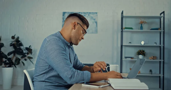 Freelancer Gafas Mirando Reloj Cerca Aparatos Escritorio Mientras Trabaja Desde —  Fotos de Stock