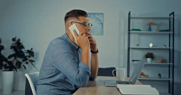 Vista Lateral Homem Preocupado Óculos Falando Smartphone Enquanto Trabalhava Remotamente — Fotografia de Stock